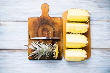 Taze ananas güneş ışığı altında ahşap bir zemin üzerine dilimlenmiş