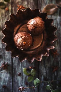 Koyu ahşap arka plan gül dalları ile cupcakes.