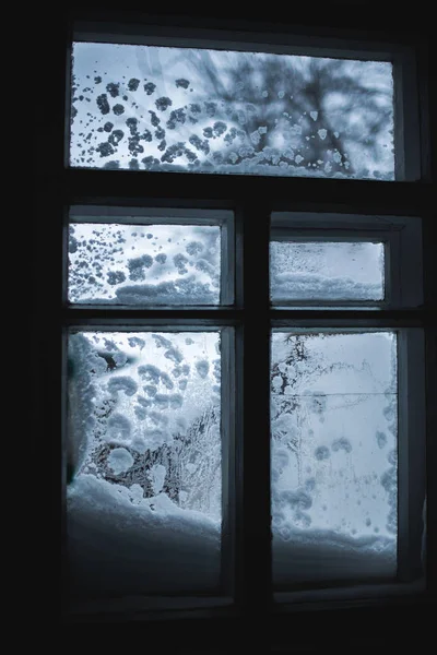 Заснеженное окно с зимним фоном — стоковое фото