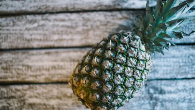 Eski bir ahşap zemin üzerine Bütün Konfit bir ananas.