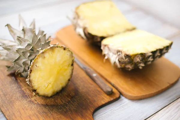 Piña fresca en rodajas sobre un fondo de madera a la luz del sol —  Fotos de Stock