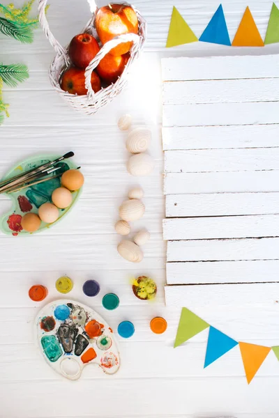 El proceso de pintar huevos de Pascua bodegón sobre un fondo de madera blanca — Foto de Stock