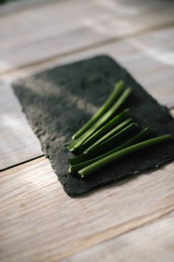 Siyah mutfak tahtası dilimlenmiş yeşil kaynaklanıyor