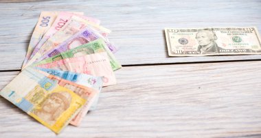 Ukraynalı hryvnia ve ahşap arka plan üzerinde Amerikan Doları