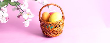 Tahta bir arka planda sepetteki paskalya yumurtaları