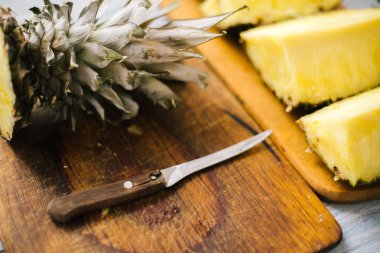 Taze ananas güneş ışığı altında ahşap bir zemin üzerine dilimlenmiş