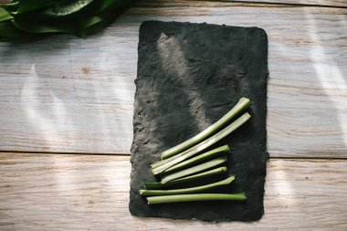 Siyah mutfak tahtası dilimlenmiş yeşil kaynaklanıyor