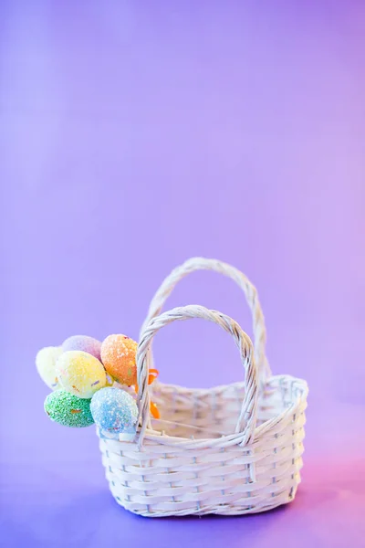 Paskalya yumurtaları bulanık bir arka plan üzerinde beyaz sepet içinde — Stok fotoğraf