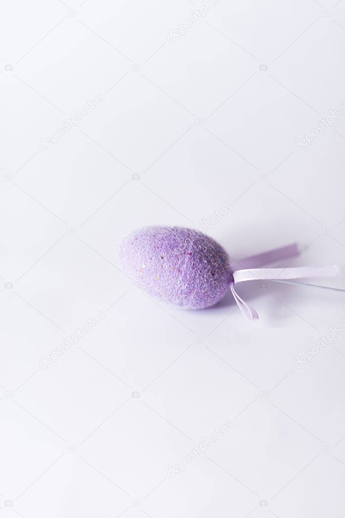 Violet easter egg on a stick on a white background