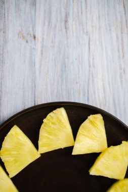 Doğranmış ahşap arka plan üzerinde ananas parçaları