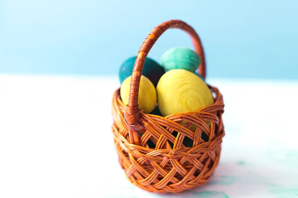 Easter eggs in a basket on a wooden background — Stock Photo, Image