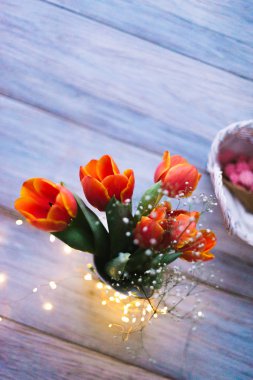 Ahşap arka plan üzerinde bir vazoda laleler