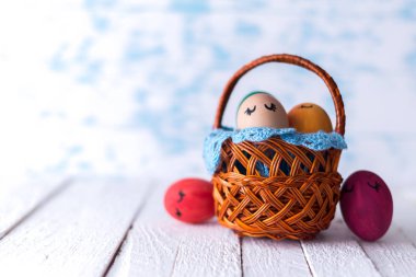 Tahta bir arka planda sepetteki paskalya yumurtaları