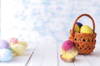 Tahta bir arka planda sepetteki paskalya yumurtaları