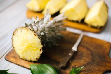 Taze ananas güneş ışığı altında ahşap bir zemin üzerine dilimlenmiş