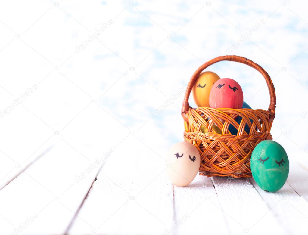 Easter eggs in a basket on a wooden background