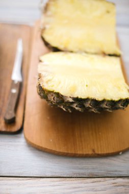 Taze ananas güneş ışığı altında ahşap bir zemin üzerine dilimlenmiş