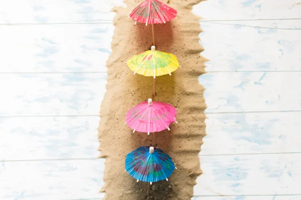 Summer concept. Beach umbrellas on a wooden blue background — Stock Photo, Image