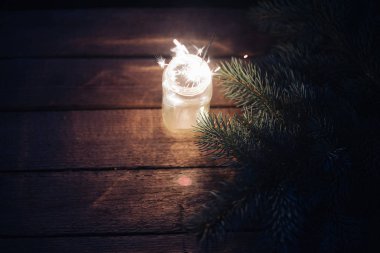 Bengal ışık bir cam kavanoza bir Noel ağacın bir ahşap zemin üzerine