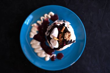 Siyah bir zemin üzerine mavi tabakta kek