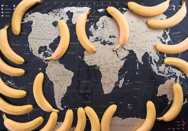 A world map in the frame with fresh bananas