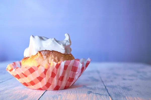 Cupcake with cream on a pastel background on a wooden table — Stock Photo, Image