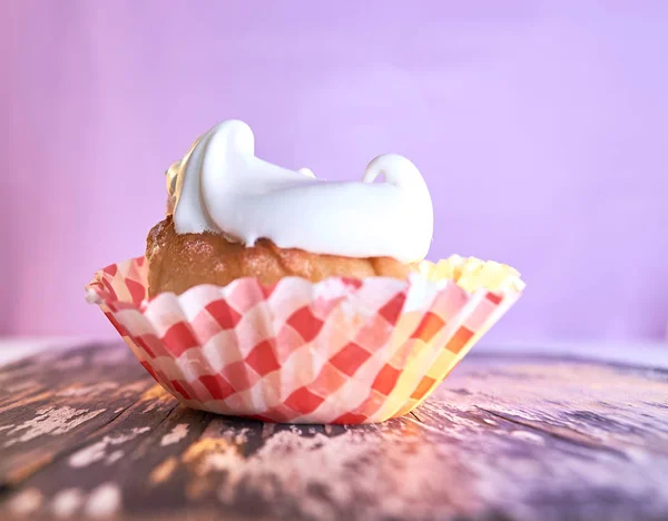 Cupcake with cream on a pastel background on a wooden table — Stock Photo, Image