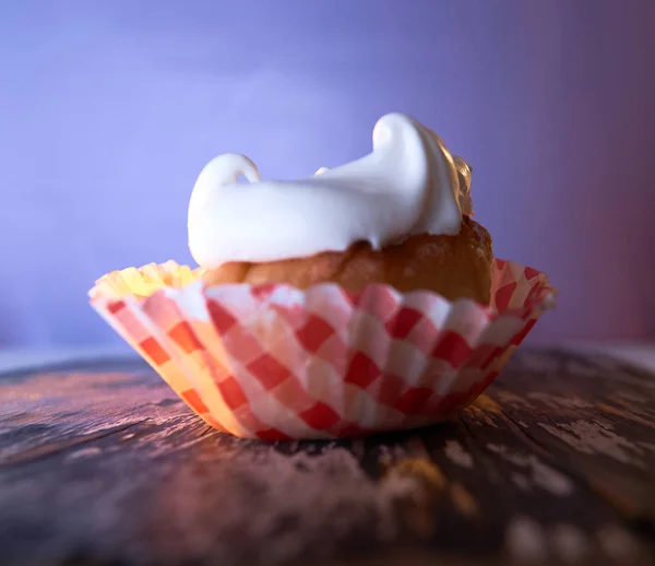 Cupcake con crema sobre fondo pastel sobre una mesa de madera —  Fotos de Stock