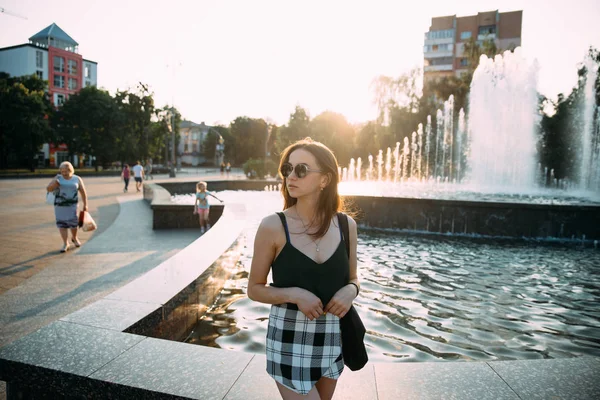 Sexy girl in short shorts and a tank top near the fountain — Stock Photo, Image