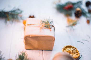 Beyaz arka planda kurumuş portakal dilimleri olan Noel hediyeleri.