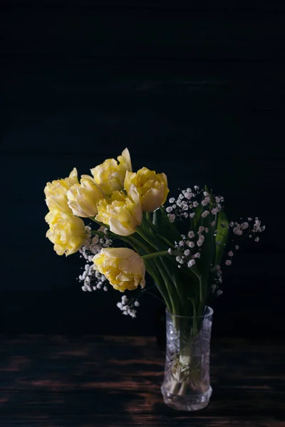 Tulipes jaunes dans un vase sur un fond en bois — Photo