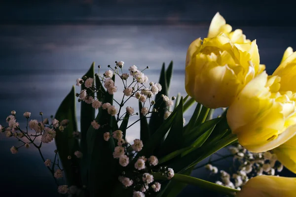 Желтые тюльпаны в вазе на деревянном фоне — стоковое фото
