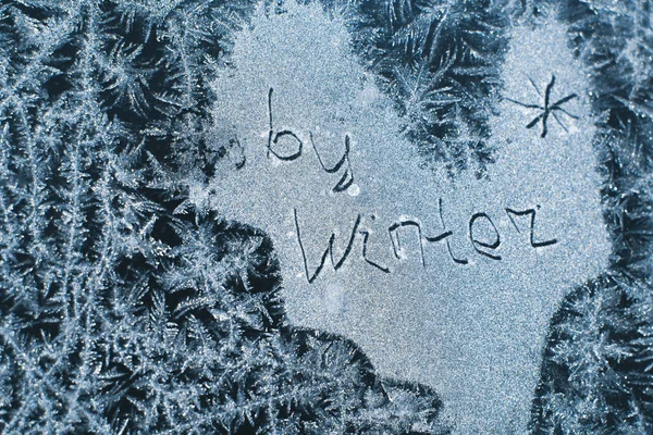 Напис: Прощай, зима. На замерзлому зимовому вікні в морозних візерунках — стокове фото