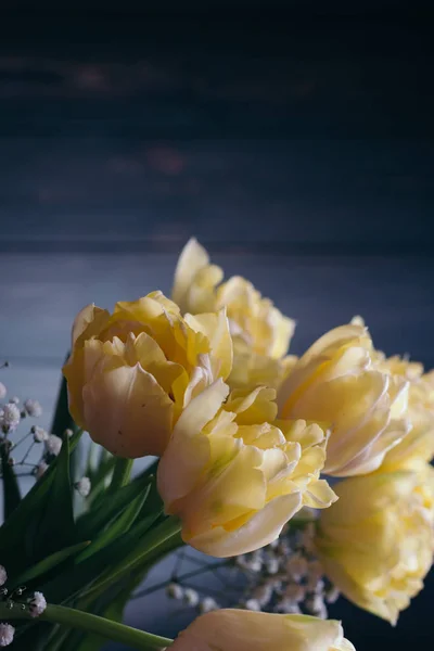 Yellow tulips in a vase on a wooden background — Stock Photo, Image