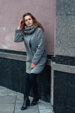 Kışın şehirde gri paltolu bir kız