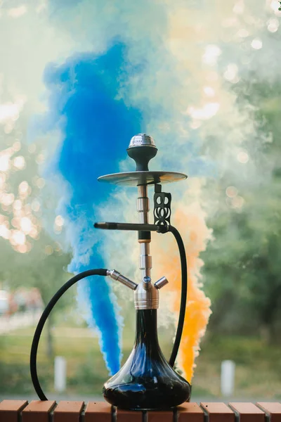 Hookah buiten op een achtergrond van gekleurde rook — Stockfoto