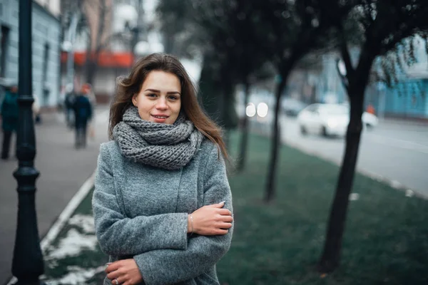 Девушка в сером пальто зимой в городе — стоковое фото