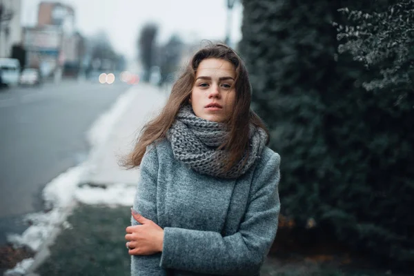 Dziewczyna w szarym płaszczu w zimie w mieście — Zdjęcie stockowe