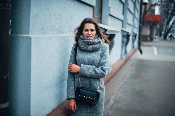 Meisje in een grijze jas in de winter in de stad — Stockfoto