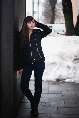 Kışın şehirde bir sokakta hırka giyen bir kız.