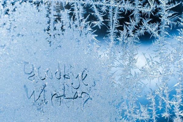 A felirat: Viszlát, téli. A fagyasztott téli ablak fagyos minták — Stock Fotó