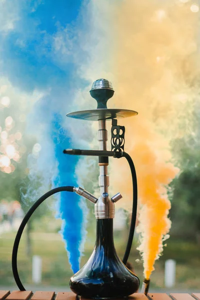 Hookah buiten op een achtergrond van gekleurde rook — Stockfoto