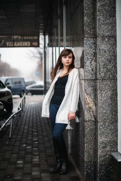Girl in winter in a cardigan on a street in the city — Stock Photo, Image