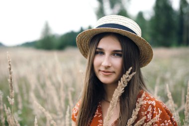 Girl in a red dress on a wheat field