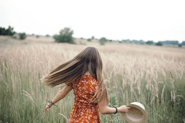 Дівчина в червоній сукні на пшеничному полі — стокове фото