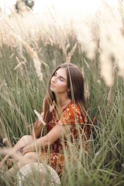 Girl in a red dress on a wheat field