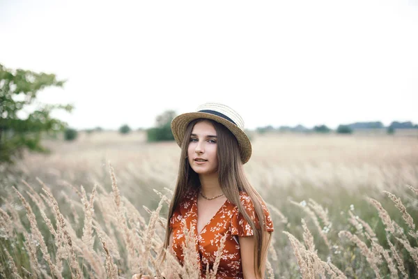 Girl in a red dress on a wheat field — Stockfoto