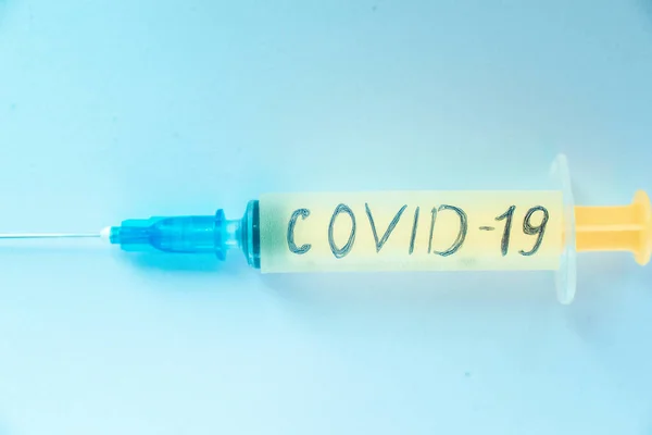 Jeringa con la inscripción coronavirus sobre un fondo claro. Concepto — Foto de Stock