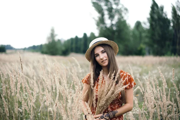 Girl in a red dress on a wheat field — Stok fotoğraf