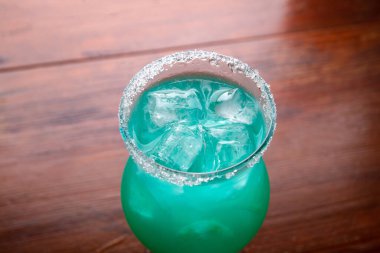 Ahşap arka planda taze deniz mavisi kokteyli.